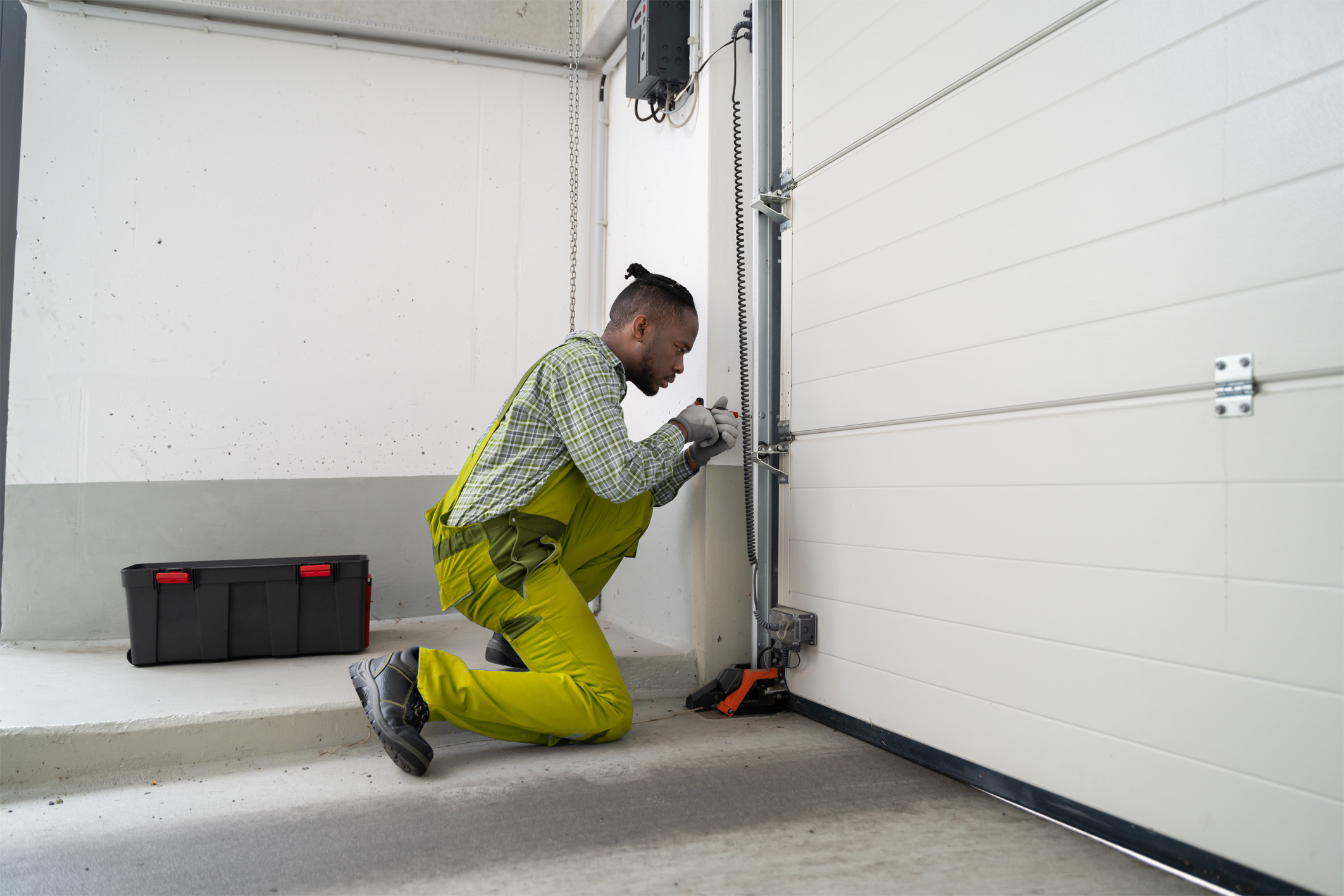 A repairman performing maintenance on a garage door